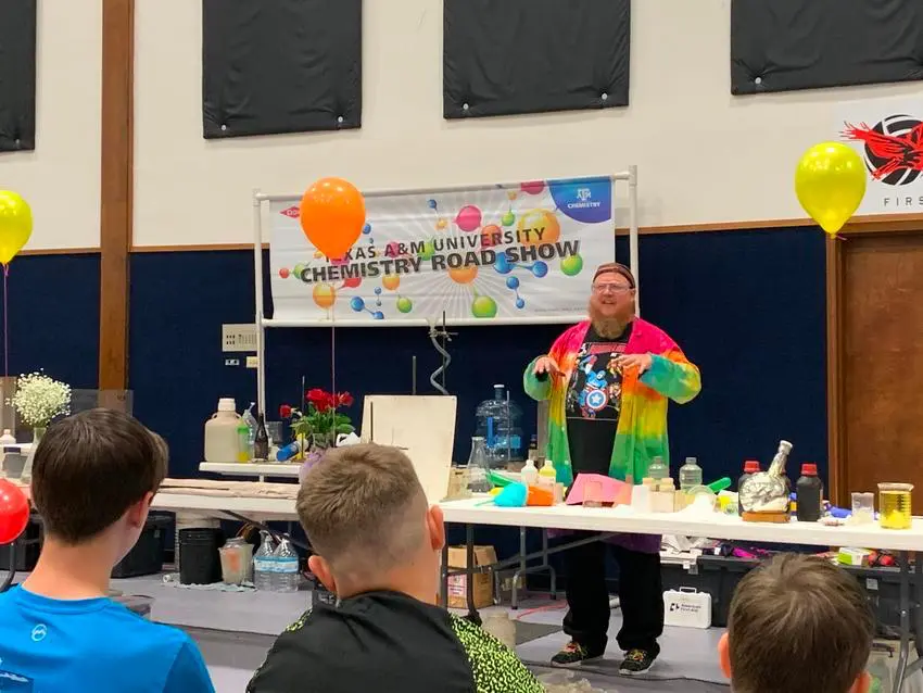 A man in a colorful shirt is holding balloons