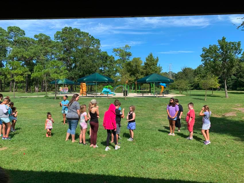 A group of people standing in the grass.